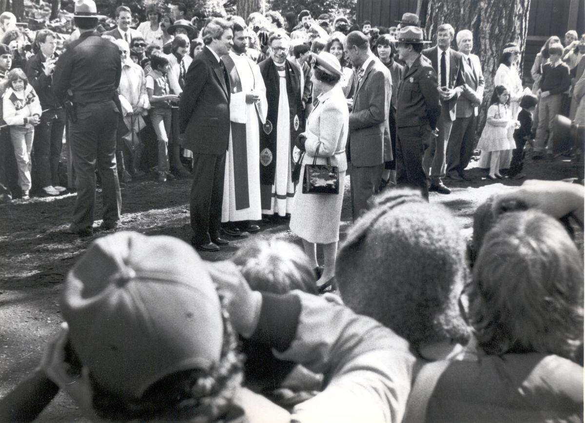 Queen Elizabeth II talks to the Rev. John C. Davis, in dark suit, after church services during her 1983 visit to Yosemite National Park. Others present: right, Rev. Victor M. Rivera, bishop of San Joaquin Valley Episcopal Diocese; center, Rod Craig, priest at Yosemite Park Church; left, Rev. John C. Davis, Presbyterian pastor at the Yosemite Community Church.