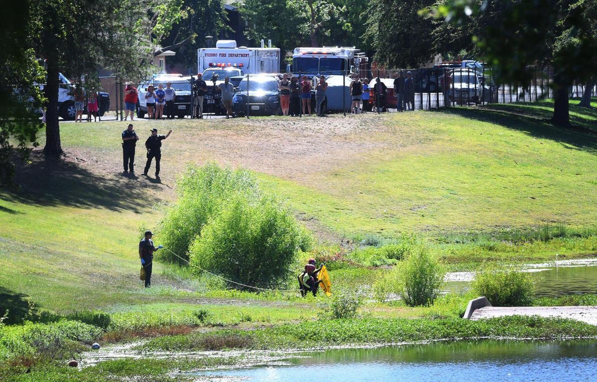 A Fresno Fire Dept. team prepares to recover a body from a ponding basin to the north of Viking Elementary school Monday afternoon, June 13, 2022 in Fresno.