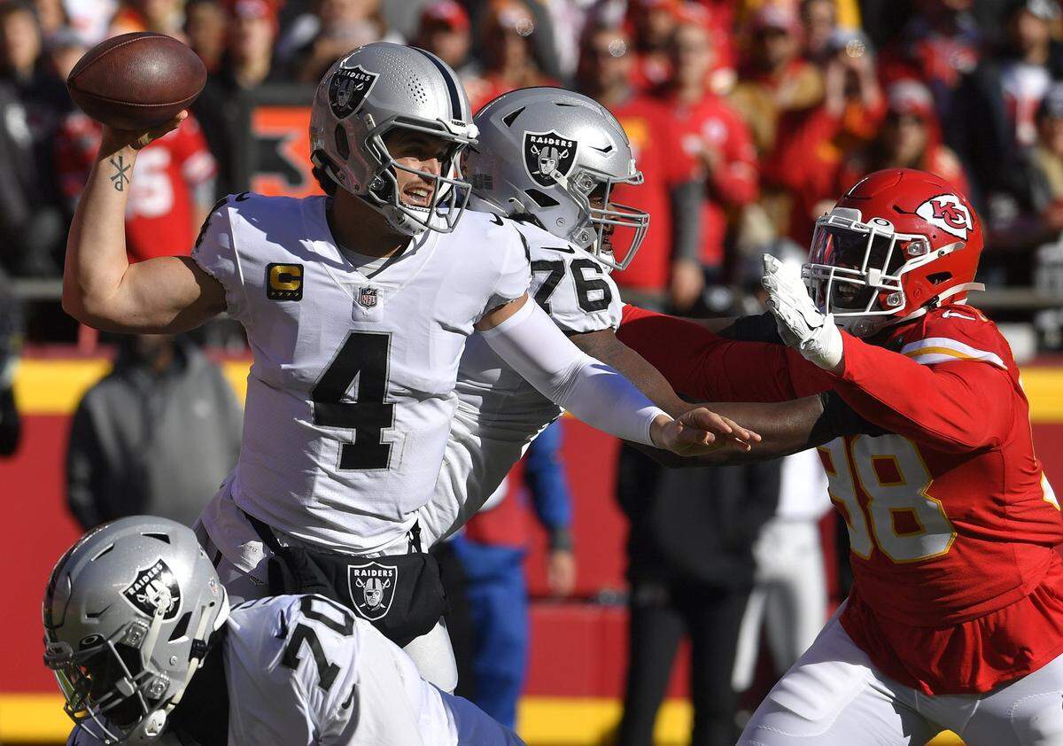 Las Vegas Raiders quarterback Derek Carr feels the pressure from the Kansas City Chiefs pass rush of Tershawn Wharton during the first half on Sunday, Dec. 12, 2021 at Arrowhead Stadium in Kansas City.