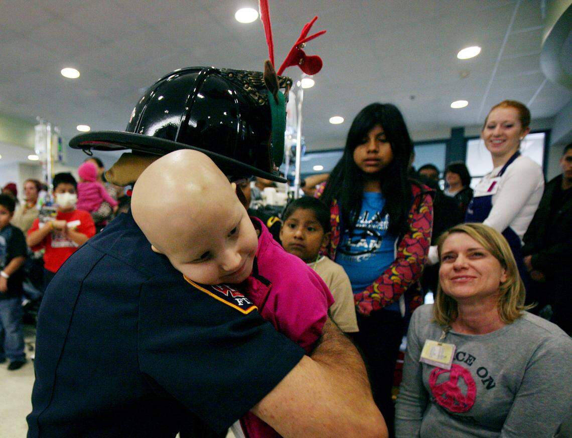 Mickey Kaitangian hugs a patient at Valley Children’s Hospital during a Christmas visit in 2010.