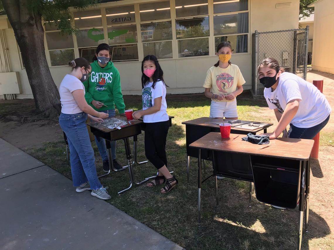 Manchester GATE sixth grade students work on their porcelain-mix ceramic leaves to be added to the valley oak mural being put together by Fresno artist David Roberts.