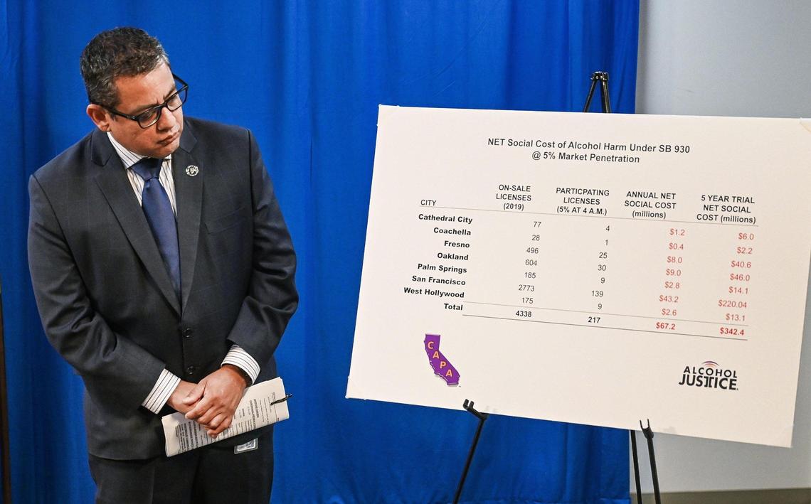 Fresno City Councilmember Miguel Arias looks over a chart explaining the social cost of alcohol harm under Senate Bill 930, during a press conference to speak out against the law, at Fresno City Hall on Tuesday, Aug. 9, 2022.