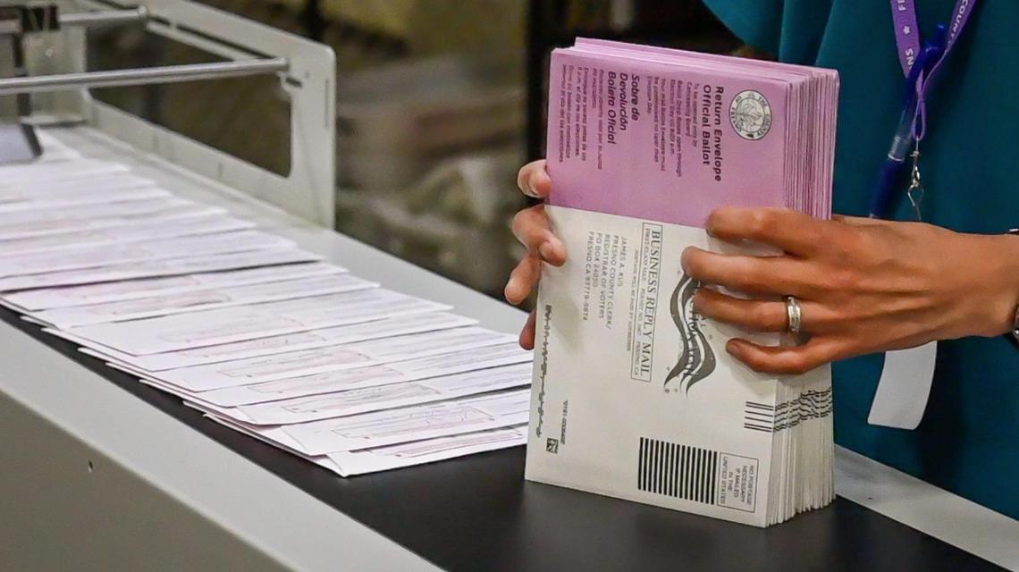 Elections office worker Jesus Diaz process ballots dropped off at county ballot boxes through a bar code scanner at the Fresno County Elections Department warehouse in Fresno on Monday, June 6, 2022.