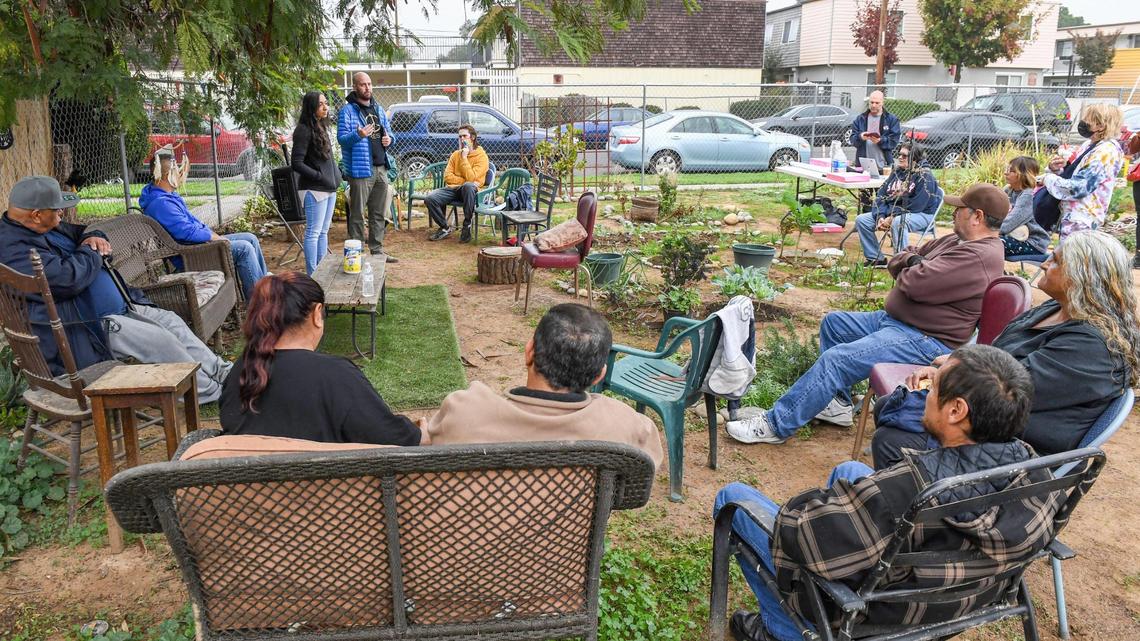 Andy Levine and Amber Crowell, co-directors of the Center for Community Voices at Fresno State, speak to neighbors at the El Dorado Park Community Garden in central Fresno about starting a guaranteed basic income program in Fresno.