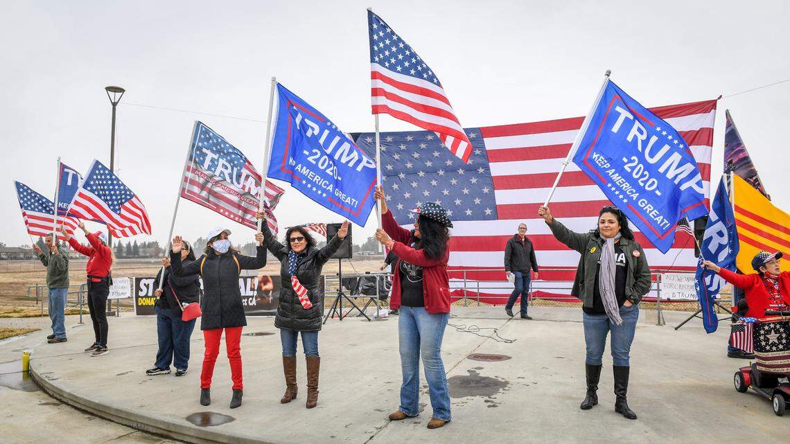 Donald Trump supporters gather on stage to dance and wave flags prior to a speaking program proclaiming the presidential election was stolen and urging supporters to continue fighting for the president, during a rally hosted by the Fresno County Republican Party at Sierra Meadows Park in Clovis on Saturday, Dec. 12, 2020.