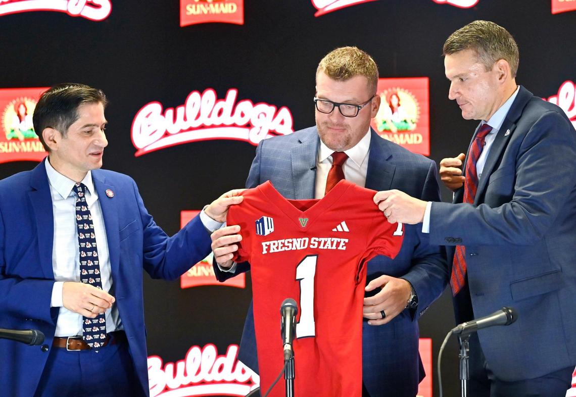 New head coach Matt Entz, center, is presented a Fresno State Bulldog jersey by Fresno State president Saúl Jiménez-Sandoval, left, and Director of Athletics Garrett Klassy, right, at a press conference Thursday, Dec. 5, 2024 in Fresno.