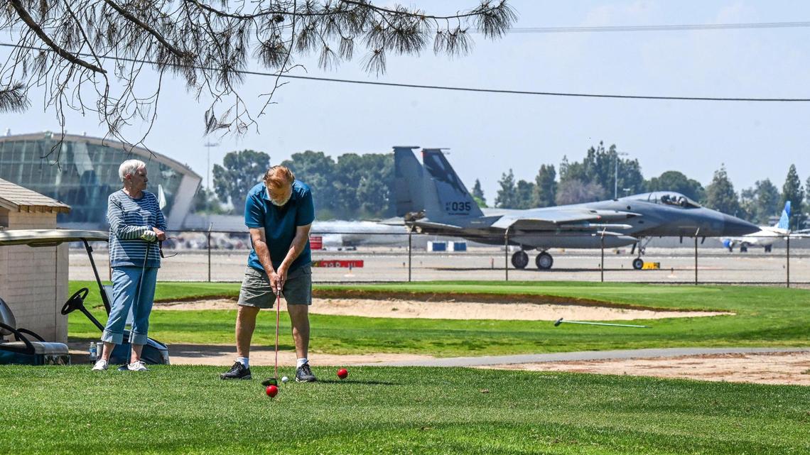 A golfer gets ready for his tee shot at Airways Golf Course as an F-15 Eagle from the 144th Fighter Wing of the Air National Guard taxies by at the adjacent Fresno Yosemite International Airport in Fresno on Thursday, May 1, 2025.