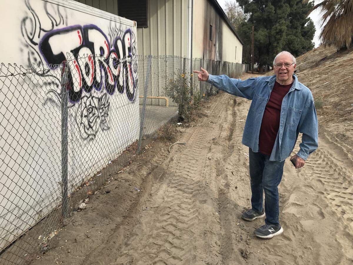 Sammy Ganimian, owner of the Hye Quality Bakery in downtown Fresno, points to fresh graffiti on his exterior refrigeration unit shortly after a city hazmat crew removed garbage and possessions from a homeless camp between his building and a Highway 41 off-ramp. Minutes after this photo was taken, a city graffiti abatement team sprayed over the tagging.