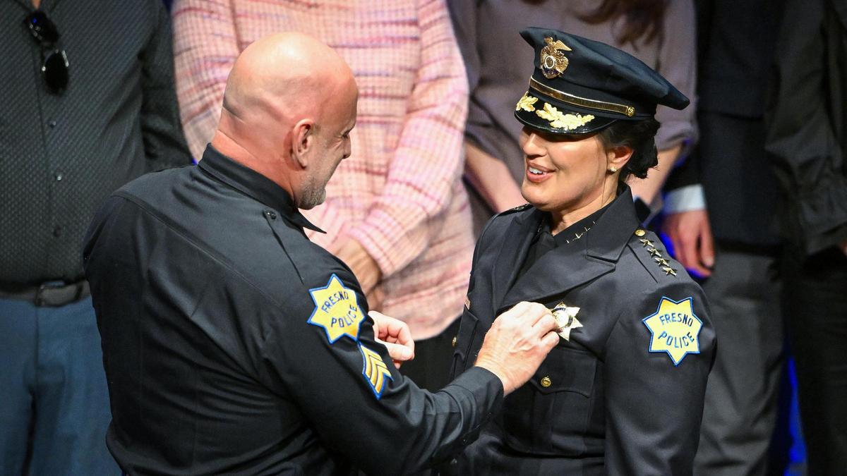Fresno police sergeant Steve Casto pins a badge on his wife, new Fresno Police Chief Mindy Casto during a swearing in ceremony held at the Saroyan Theatre in Fresno on Friday, Feb. 28, 2025.