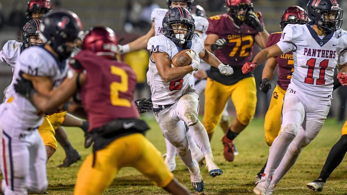 Memorial running back Brandon Ramirez, center, looks for daylight through the Clovis West defense on a run during their Central Section semifinal playoff game at Lamonica Stadium in Clovis on Friday, Nov. 18, 2022.