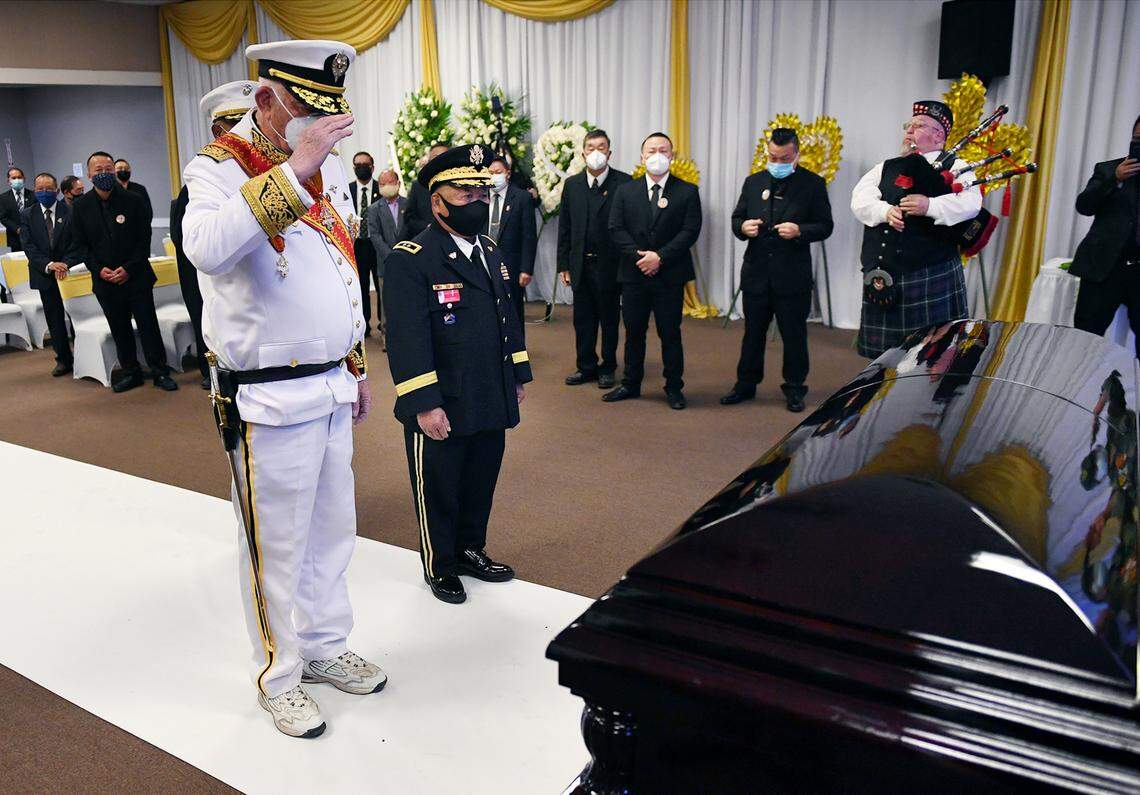 Lt. General Dean Murphy, LKC, left, with Major General Chue Chou Tchang in the center, salutes the casket carrying Col. Wangyee Vang, Ph.D, on the first of the three-day memorial service Saturday morning, March 13, 2021 in Fresno. Vang was the leader of a national Laos-Hmong veterans group and served in the U.S. Secret Army during the Vietnam War.