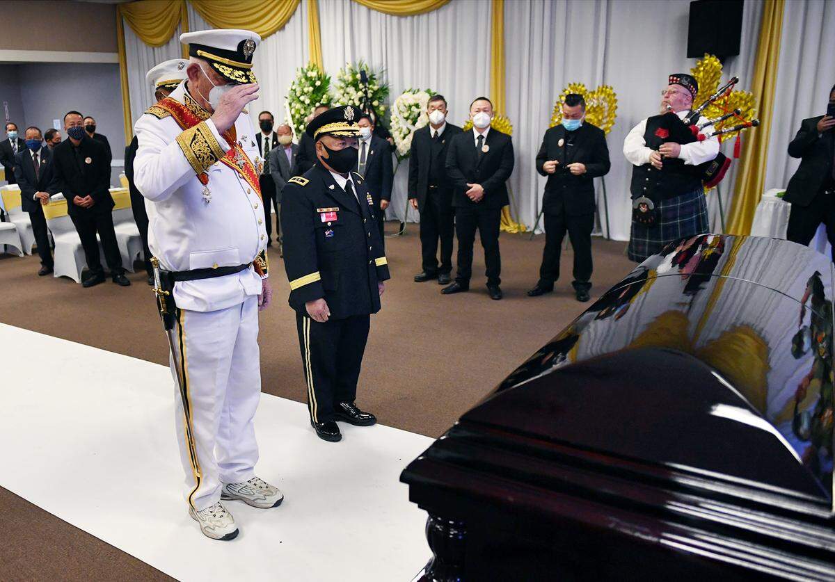 Lt. General Dean Murphy, LKC, left, with Major General Chue Chou Tchang in the center, salutes the casket carrying Col. Wangyee Vang, Ph.D, on the first of the three-day memorial service Saturday morning, March 13, 2021 in Fresno. Vang was the leader of a national Laos-Hmong veterans group and served in the U.S. Secret Army during the Vietnam War.