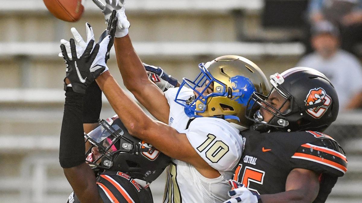 Clovis wide receiver Jaden Carrillo, center, goes up for the ball in the end zone but has it intercepted by Central’s Bubba Carter, left, as teammate Imari Conley backs him up during their game at Deran Koligian Stadium in Fresno on Friday, Oct. 1, 2021.