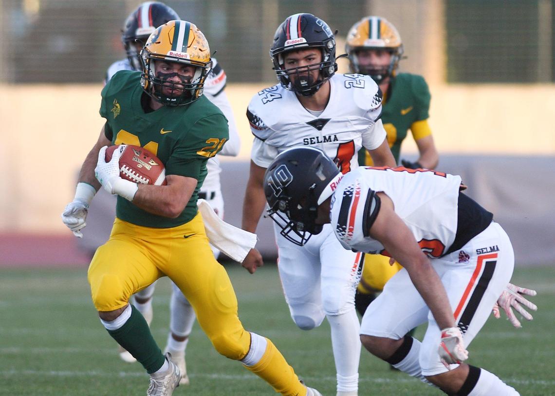 Kingsburg High’s Micah Spomer, left, is chased by Selma High’s Aaron Blancas, right, Friday, April 16, 2021 in Kingsburg.