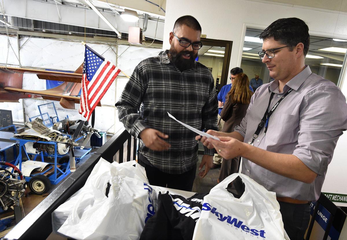 San Joaquin Valley College aviation technology student Ben Almaguer goes over paperwork with SkyWest Airlines director of maintenance Eli Mayes during a recruitment session March 9, 2022. SkyWest Airlines is partnering SJVC for a scholarship and apprenticeship program to hire graduates of the school’s aviation maintenance program.