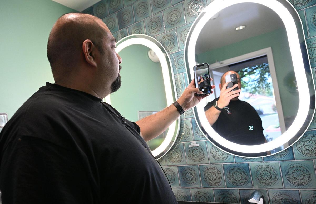Jesse Toledo at the family’s newly opened Toledo’s Mexican Restaurant at Cedar and Nees avenues demonstrates the variable lighting designed for selfies in the women’s restroom.