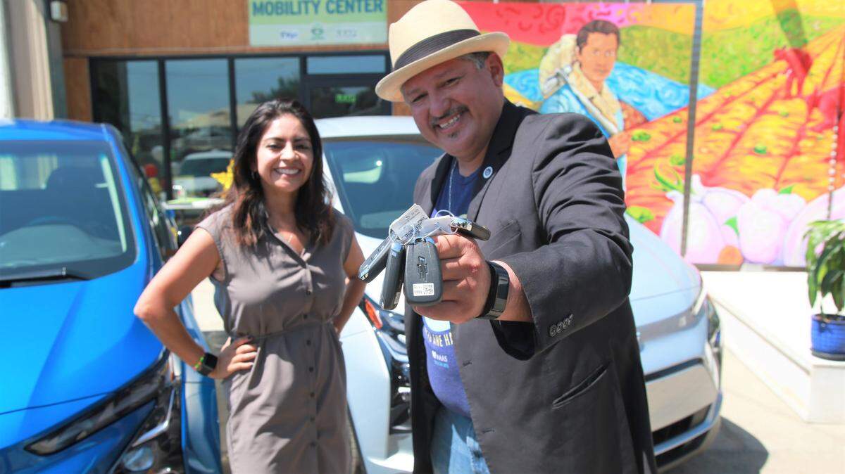 Huron Mayor Rey León, who is also executive director of the LEAP Institute (right) with General Motors regional director Juanita Martínez with the keys of the four Chevrolet Bolt electric vehicles provided by GM as a loan for six months to increase equitable access to COVID-19 vaccinations and testing by expanding sustainable transportation options to Fresno County farmworkers and their families.