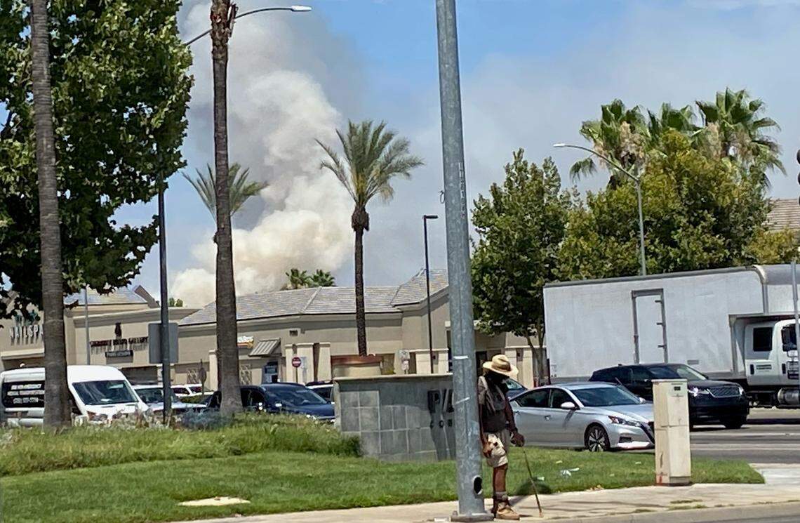 Smoke can be seen at Herndon and Palm avenues from a river-bottom fire near Woodwark Park on Saturday, July 3, 2021, in Fresno, California.