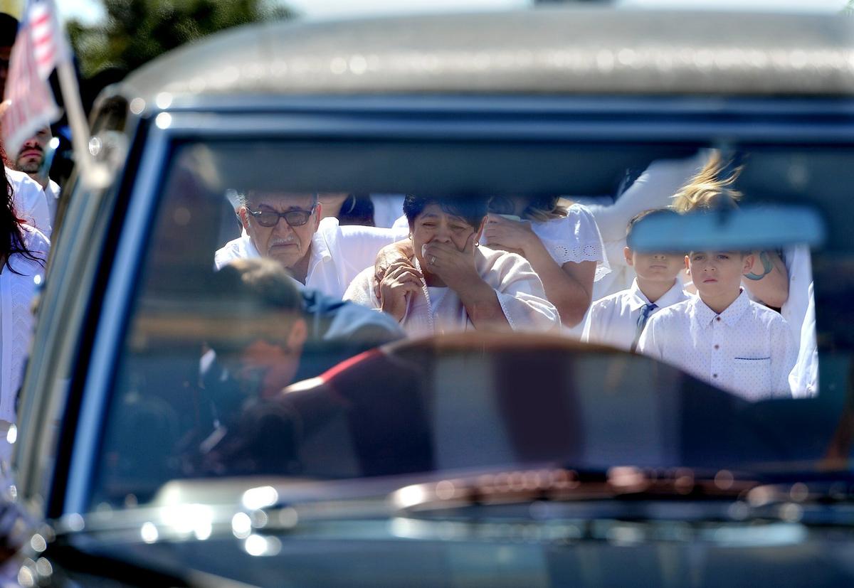 Family members look to the flag-draped casket of deported Marine veteran, Enrique Salas, after it was placed in a hearse after a funeral Mass at St. Anthony of Padua Catholic Church in Reedley, Friday morning, April 20, 2018.