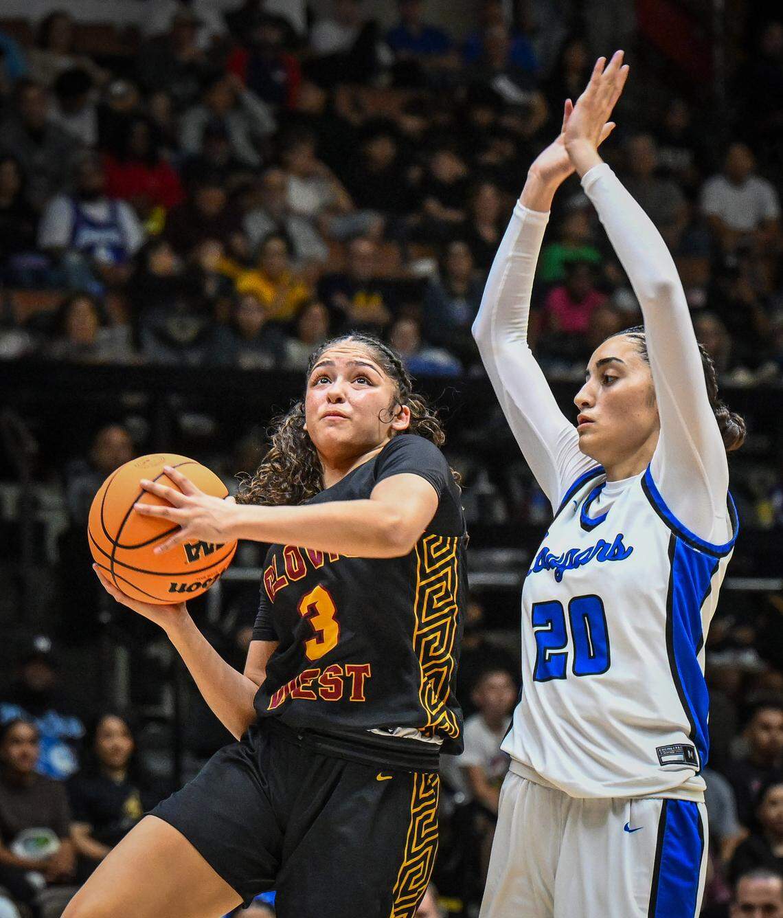 Clovis West's Ramie Chatman, left, drives to the hoop while guarded by Clovis' Milly Rojas during their Central Section Division 1 girls basketball championship game at Selland Arena on Saturday, Feb. 28, 2026.