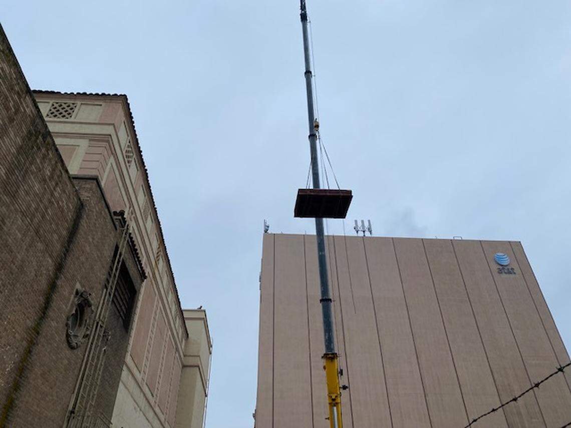 A crane was used to remove the old smoke ventilation system from the top of the Warnors Theater.