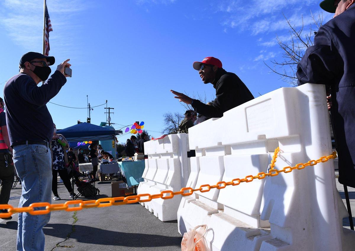 A protester, left, engages with a counter-protester, right, as about 100 people gathered across from the Tower Theatre to protest rezoning and the purchase of the theater by Adventure Church on Sunday morning, Feb. 21, 2021 in Fresno.
