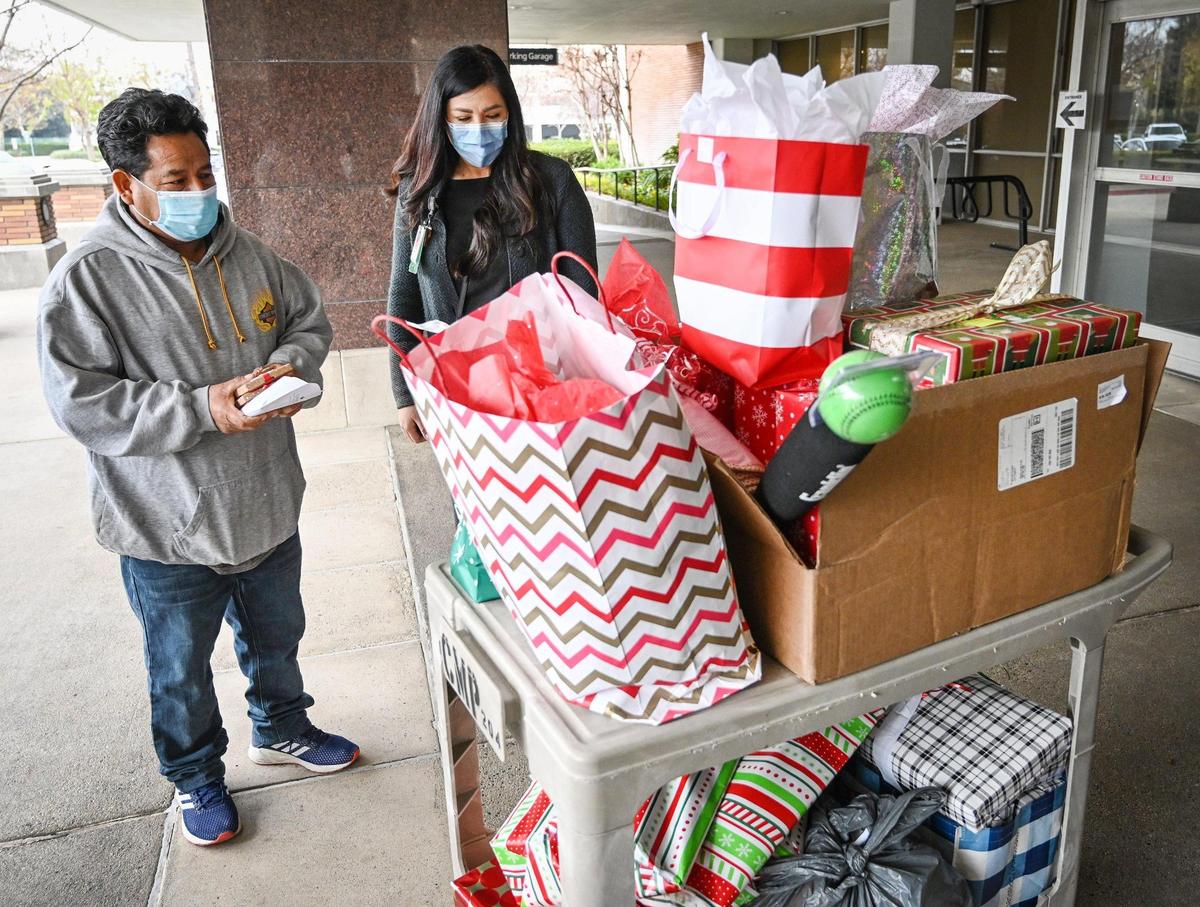 Adrian Ortiz-Escobar looks over carts of toys and gifts collected and donated by hospital staff at Community Regional Medical Center on Wednesday, Dec. 22, 2021, after his wife died from a rare disorder related to her pregnancy.
