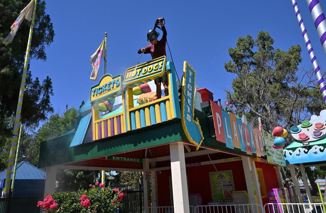 A worker spray cleans the signage at Playland Fresno in Roeding Park as it prepares for this weekend’s Summer Jam 2024. Photographed Thursday morning, June 20, 2024 in Fresno.