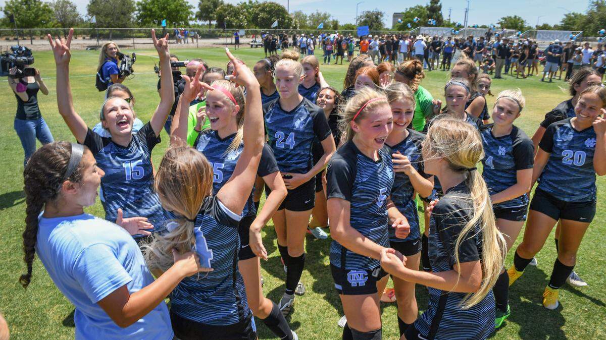 The Clovis North High School girls soccer team celebrates at mid-field after repeating as Central Section Division-1 champions after defeating Buchanan 2-1 on Saturday, May 29, 2021.