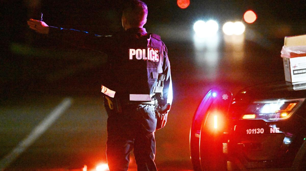 A Fresno police officer directs traffic from northbound Friant Road onto eastbound E Champlain Drive as emergency personnel respond to the scene of a multiple vehicle accident with fatalies along Friant Friday night, Oct. 13, 2023 in Fresno.