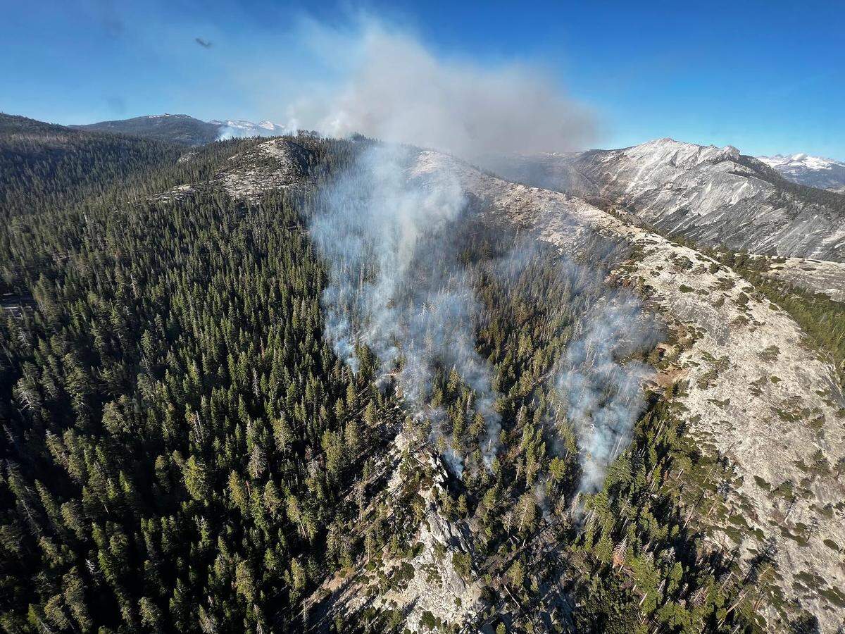 Smoke rises from a wildfire at Yosemite National Park, just west of North Dome that was sparked by lightning on June 29, 2023.