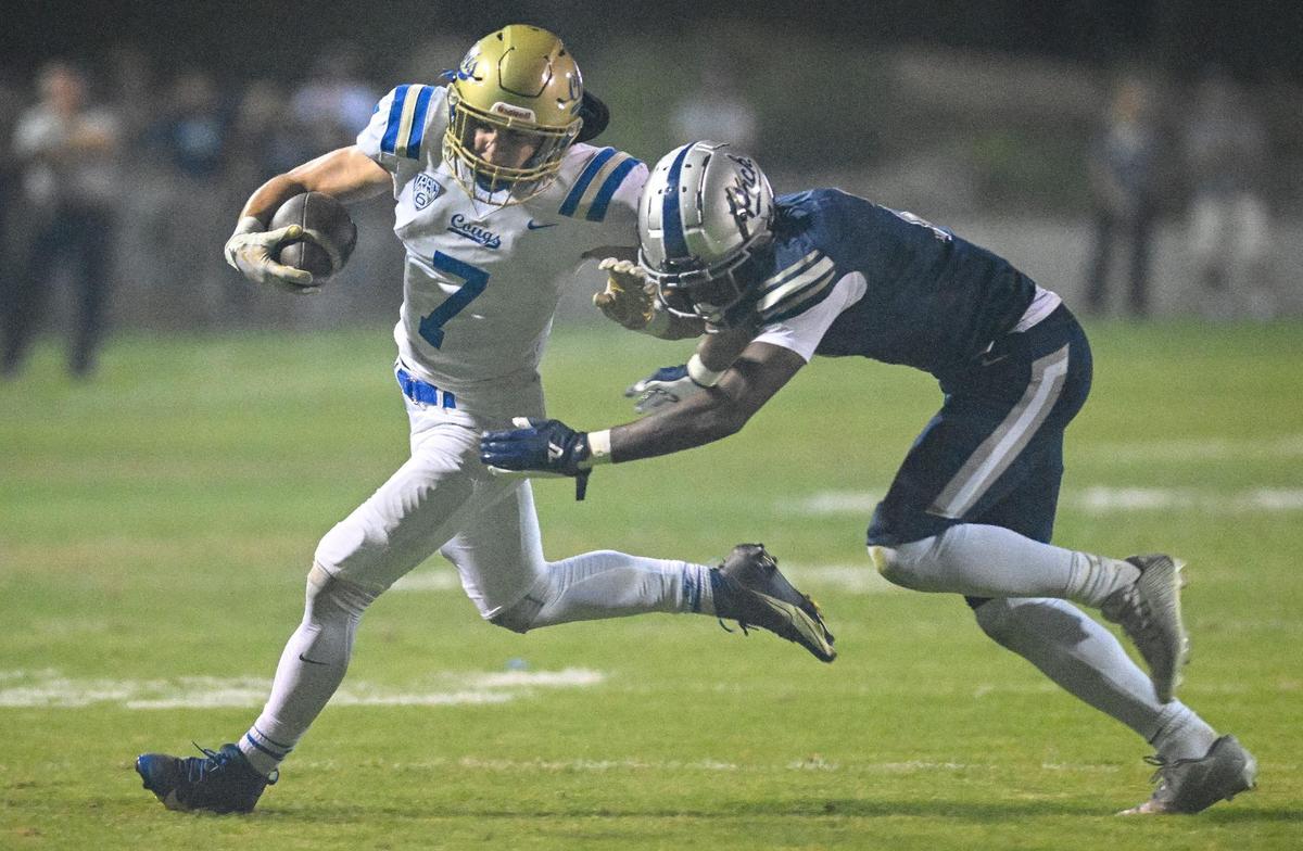 Clovis’ Nate Reinhold, left, tries to get outside of Clovis East defender Harold Duvall during their game at Lamonica Stadium on Friday, Oct. 20, 2023.