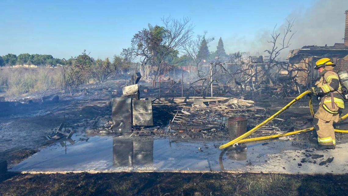 Fire crews extinguish brush fire that destroyed two homes in Madera Tuesday night.
