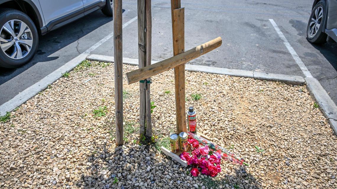 A memorial consisting of a large wooden cross, cans of beer, flowers and a can of brake parts cleaner has emerged in the McDonald’s parking lot on Thursday, April 24, 2025 where 18-year-old Caleb Quick was shot and killed on Wednesday night.