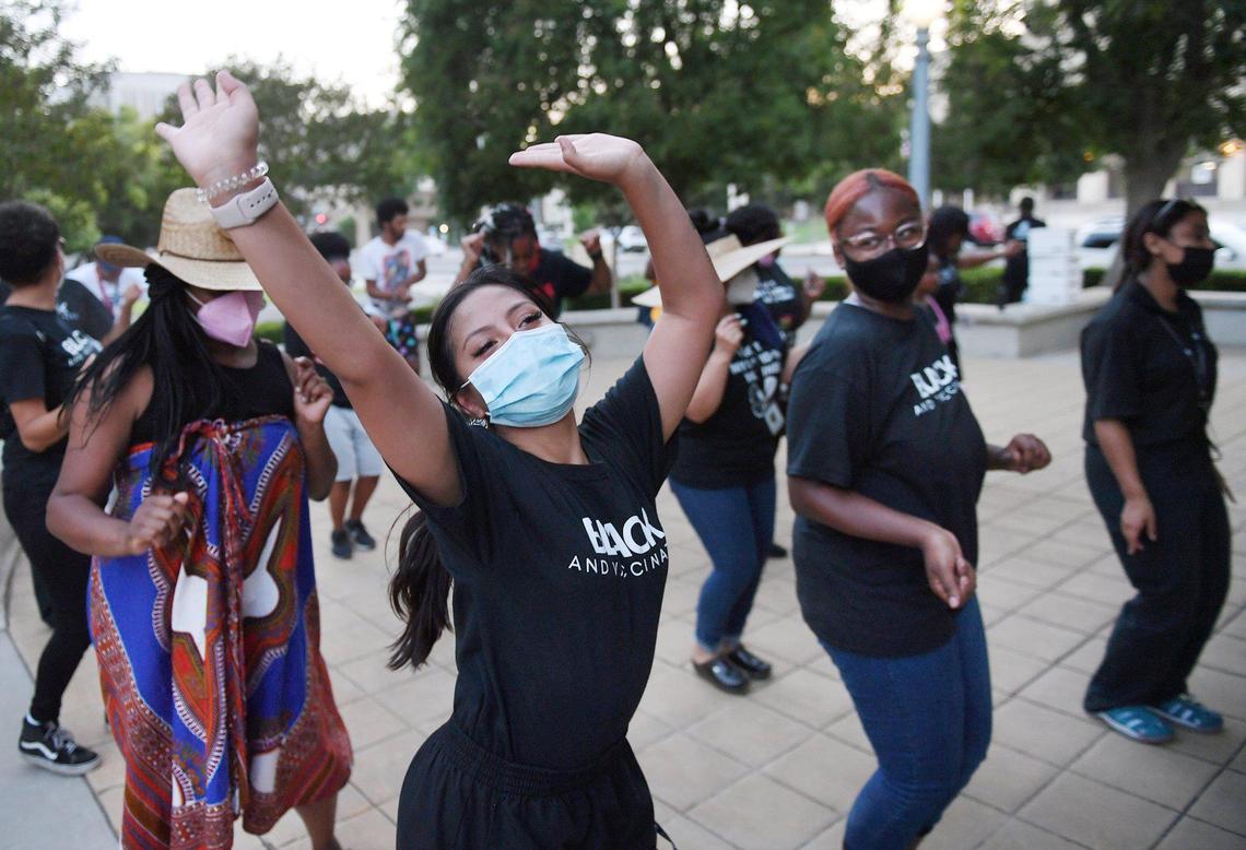 Kaeli Brooks, center, joins others as they dance to music at the Black Lives Matter Day: Black Joy event held next to the historic water tower at Eaton Plaza on Friday evening, June 18, 2021 in Fresno. The event was sponsored by the Fresno State chapter of NAACP and a coalition of other groups.