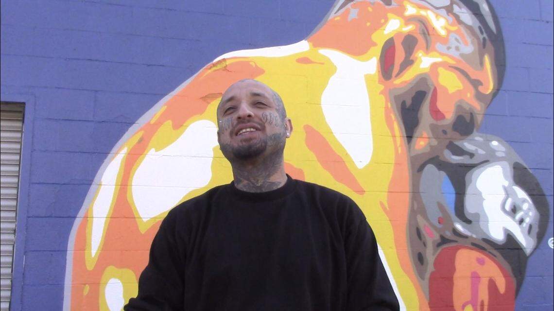 Omar “Super” Huerta stands in front of his mural of boxing champion Jose Ramirez.