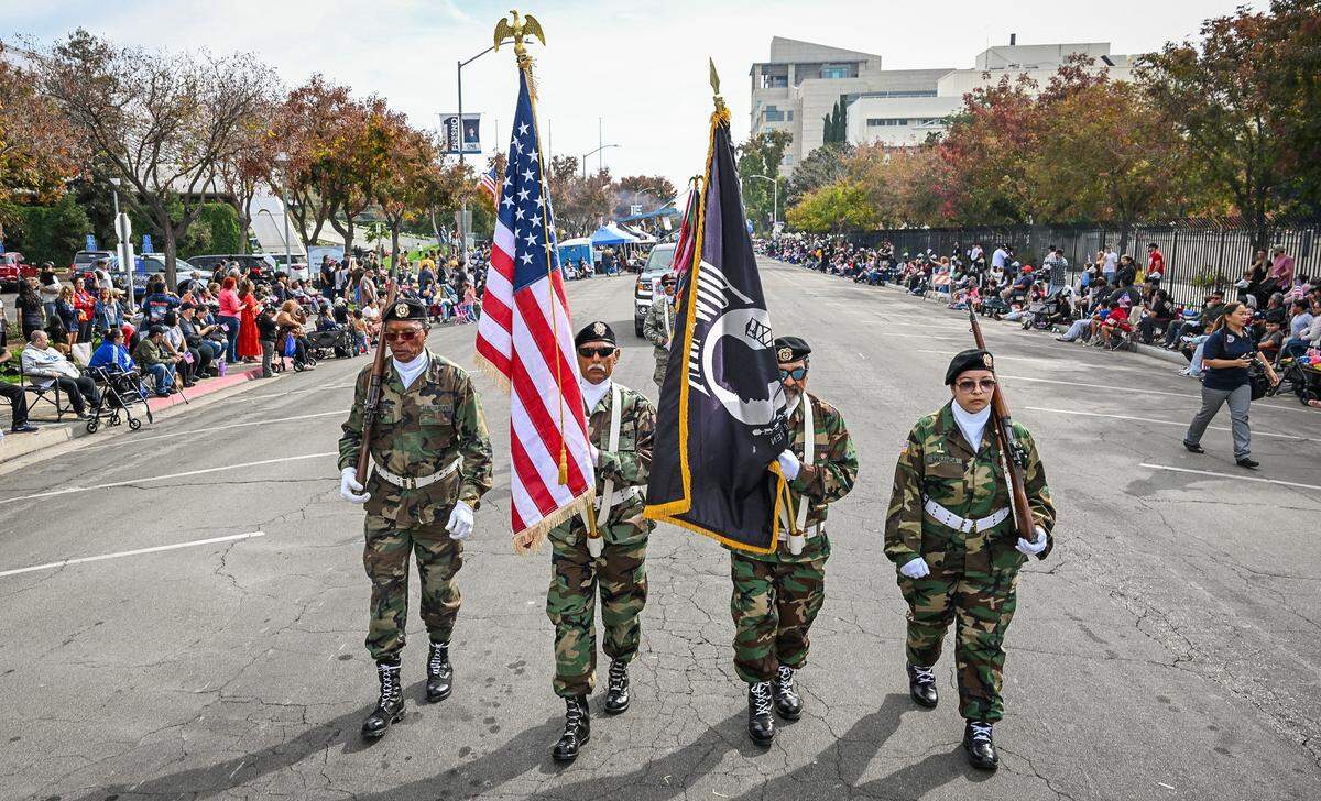 Member of the VFW Post 8900 carry flags down P Street at the start of the Central Valley Veterans Day Parade in downtown Fresno on Tuesday, Nov. 11, 2025. 