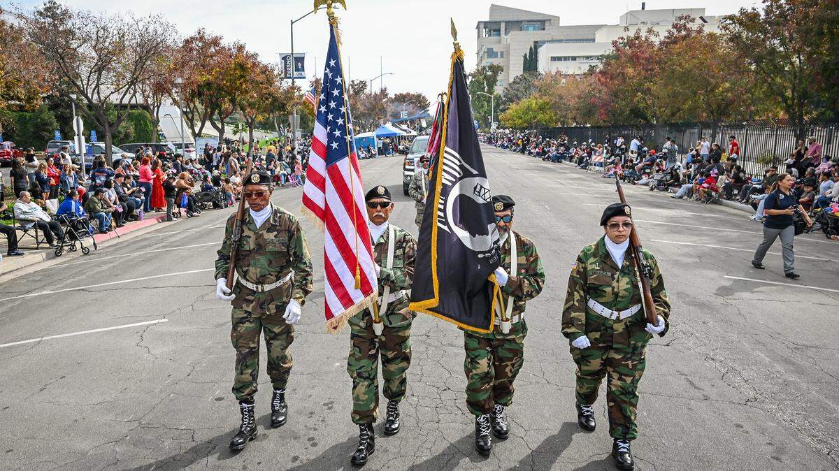 Member of the VFW Post 8900 carry flags down P Street at the start of the Central Valley Veterans Day Parade in downtown Fresno on Tuesday, Nov. 11, 2025.
