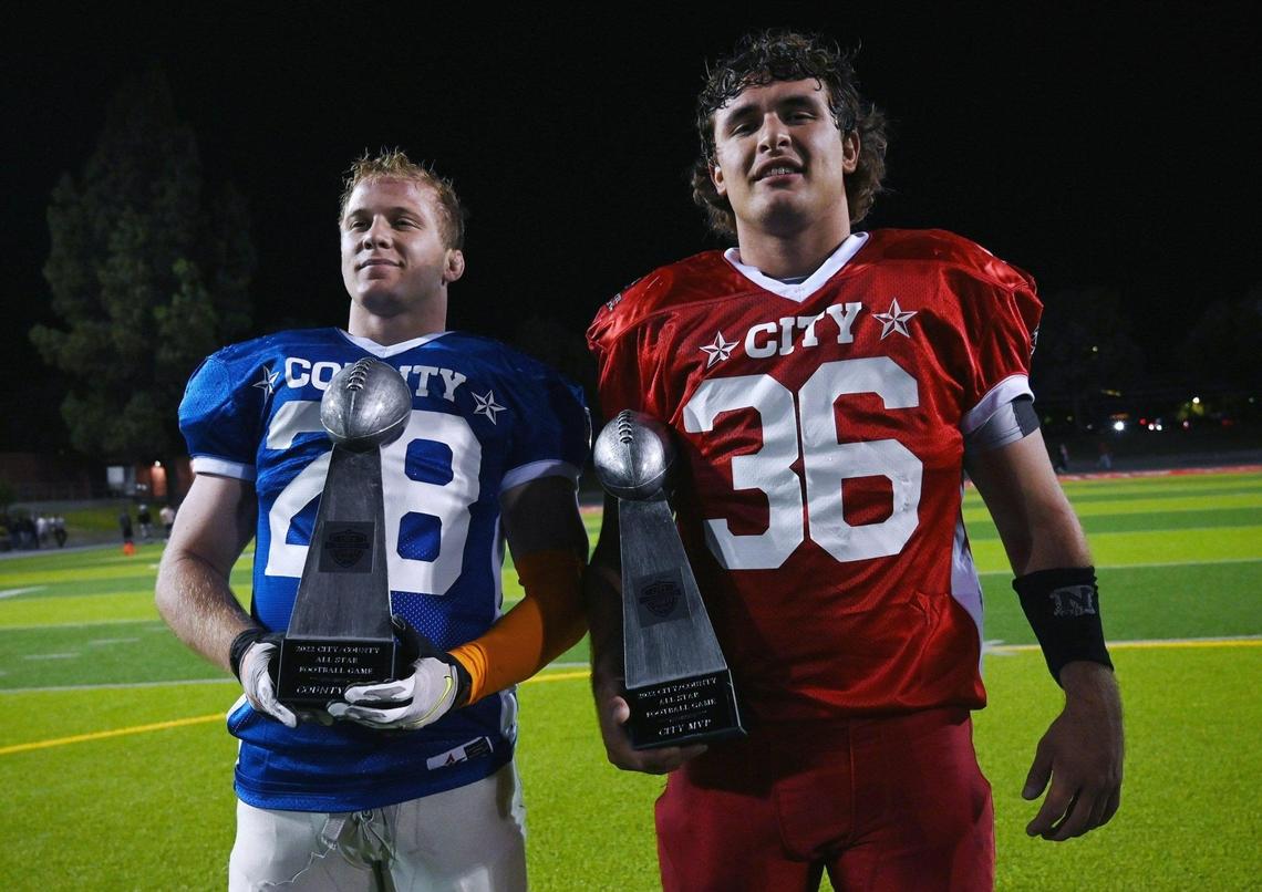 Buchanan’s Caden Rogers, left, playing for County, and Clovis North’s Paul Sharp, right, for City, are awarded MVP for both teams after the City/County All-Star football game held at McLane High’s stadium Friday night, June 17, 2022 in Fresno. The game ended 21-21.