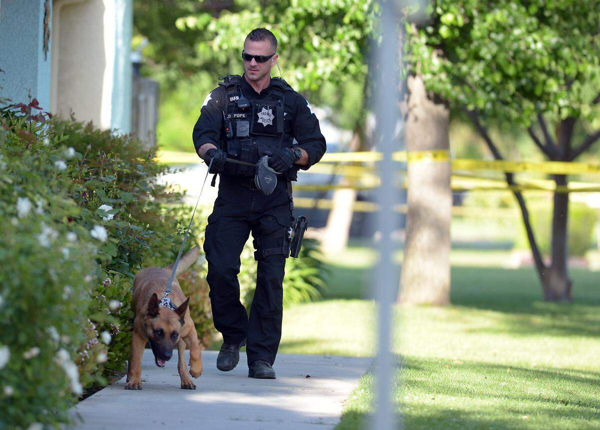 A Fresno police officer and his police dog look for evidence in the April 15, 2017, police shooting of 16-year-old Isiah Murrietta-Golding at First Street and Keats Avenue, north of Shaw Avenue.