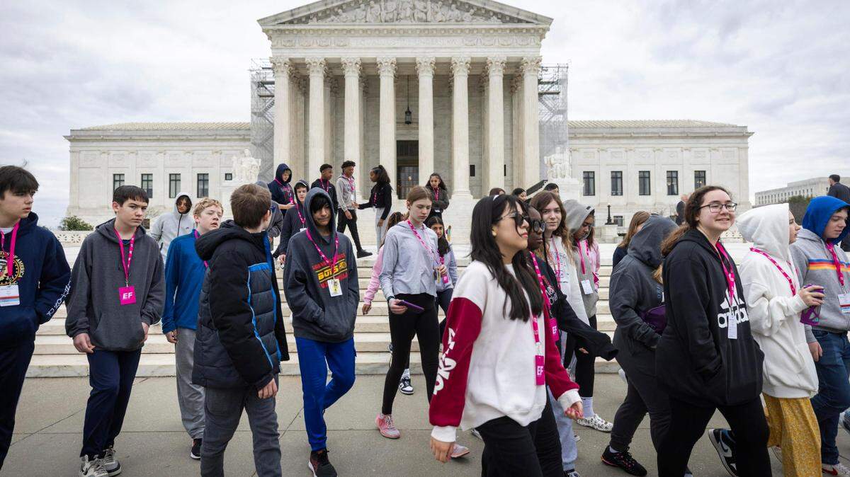 Unos estudiantes pasan junto a la Corte Suprema de los Estados Unidos, donde los jueces superiores dictaminaron por unanimidad que la cláusula de insurrección de la 14ª enmienda no impedirá que el ex presidente estadounidense Trump aparezca en la boleta electoral de Colorado.