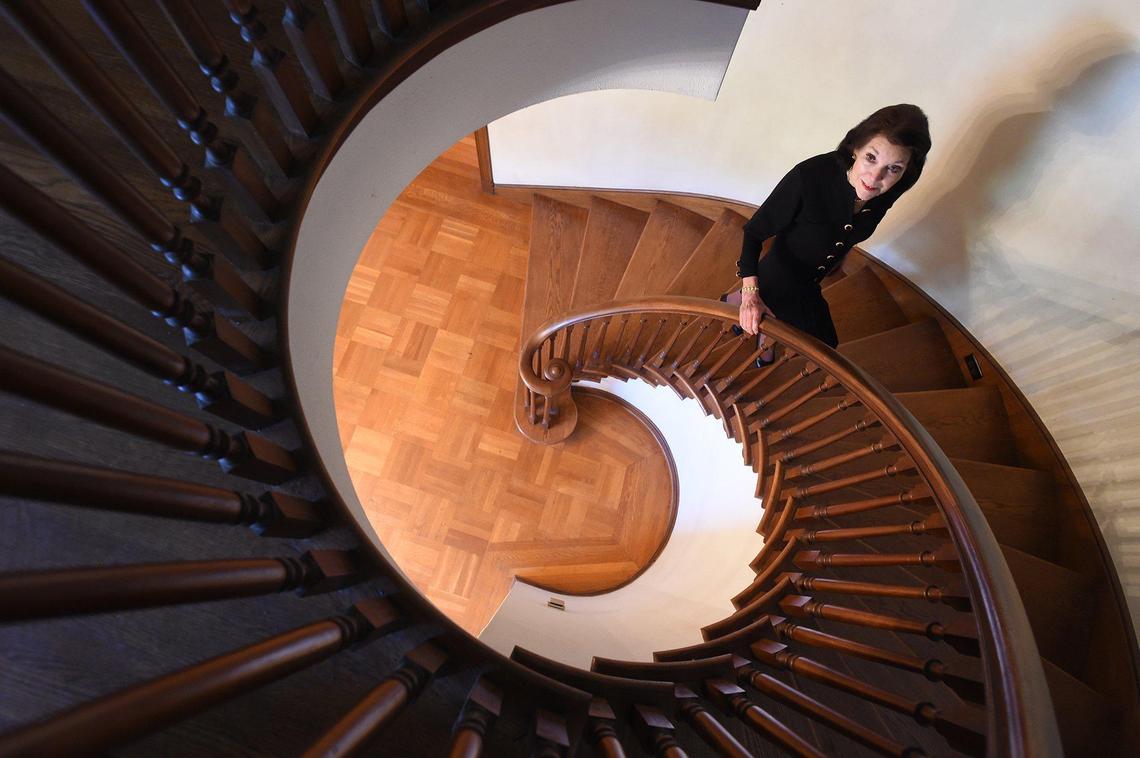 Penny Raven, owner of “Villa Corvino,” ascends a testament to craftmanship dating to the Huntington Boulevard mansion’s 1939 construction, the ornate spiral staircase. Home to the Ravens for 50 years, host of many elaborate gatherings, attended by political leaders and stars from the movie and television industry. The little more than 6,000 square-foot mansion is now for sale. She said Villa Corvino is Raven home in Italian.