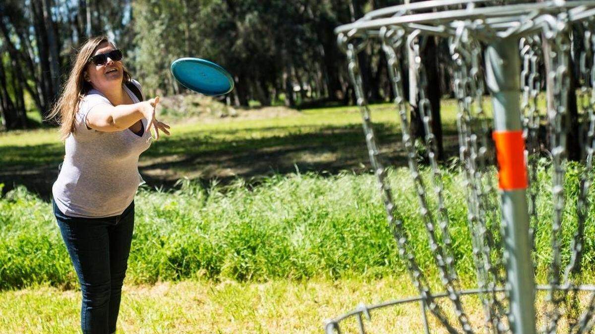 Merced resident Christina Goins putts while playing disc golf at Fahrens Park in Merced on Wednesday, March 30, 2016. The park consists of a 21 hole disc golf.