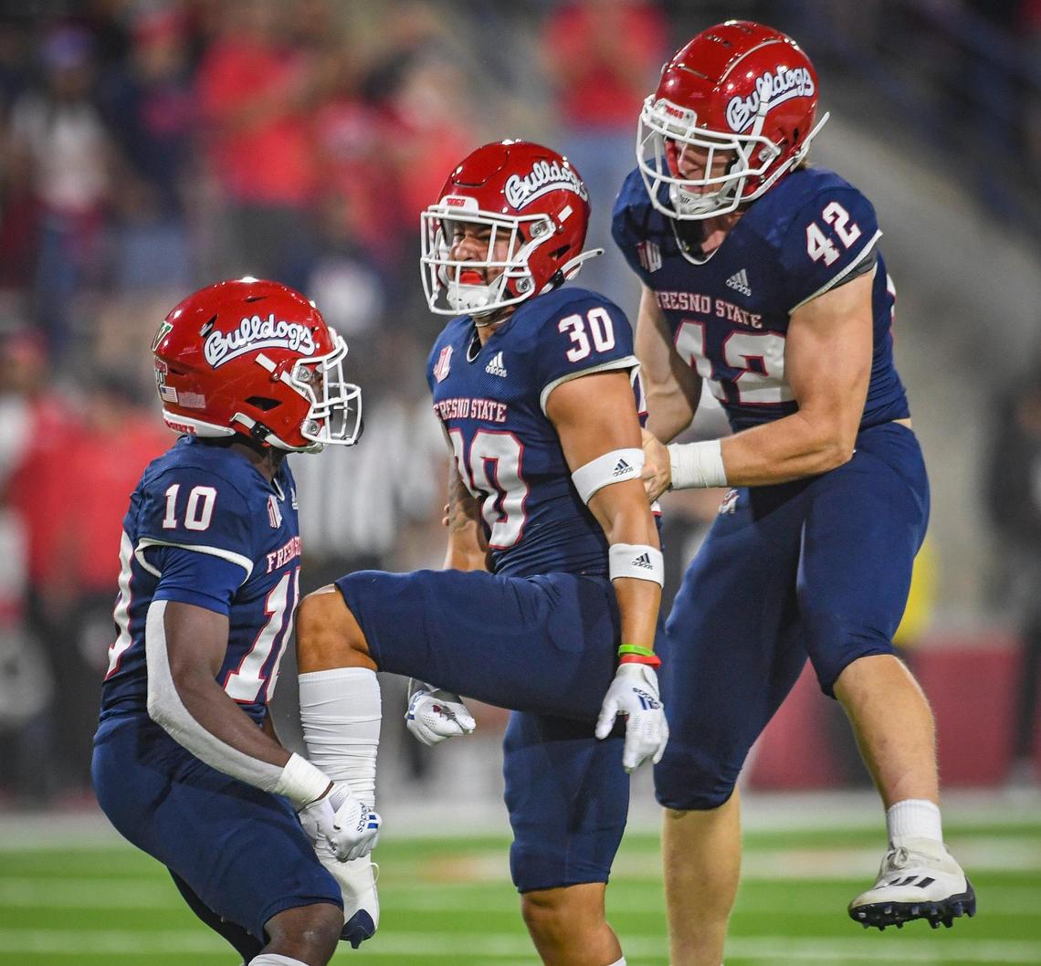 Fresno State special teams defenders, from left, Kosi Agina, Kenny Gagnon, and Tyler Mello celebrate after pinning UNLV deep on their end of the field during their game at Bulldog Stadium on Friday, Sept. 24, 2021.