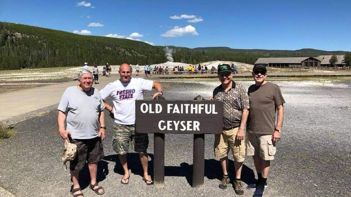 Fresno developers John Shehadey and Richard Caglia pose with Fresno Mayor Lee Brand and District 4 Councilman Paul Caprioglio near a sign for the Old Faithful Geyser in Yellowstone National Park.