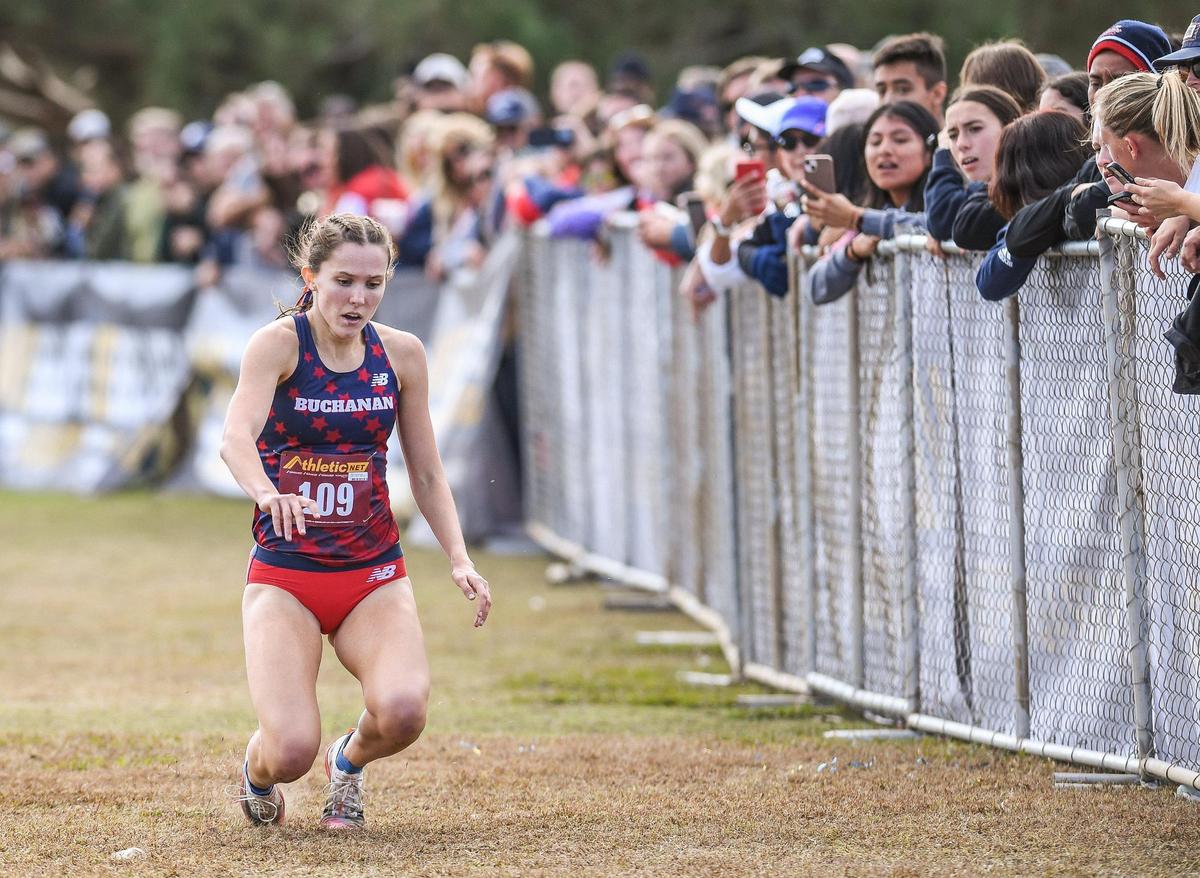 Buchanan’s Grace Hutchison collapses just short of the finish in the Central Section girls Division 1 cross country race at Woodward Park in Fresno on Thursday, Nov. 17, 2022. Hutchinson was able to get up and cross the finish second to teammate Kynzlee Buckley.