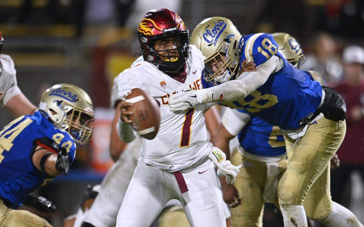 Clovis High's Brock Hartmann, right, sacks Clovis West quarterback Jamar (JJ) Howard, center, Friday, Nov. 14, 2025 in Clovis. Clovis led 21-7 at halftime.