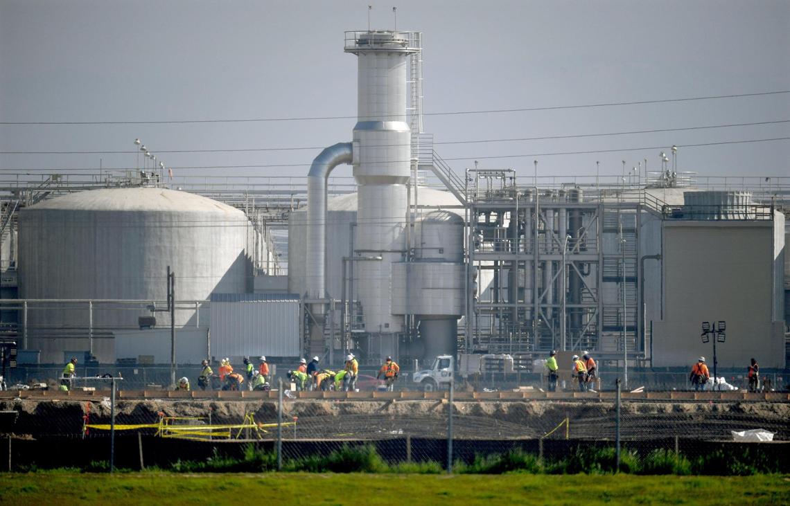Against the backdrop of the E.J. Gallo winery, construction crews lay the foundations for part of the new 183,000-square-foot Amazon “last mile” warehouse in east Fresno, Feb. 9, 2022. The site is wrapped around the former Sunnyside Drive-In at Olive and Clovis avenues.