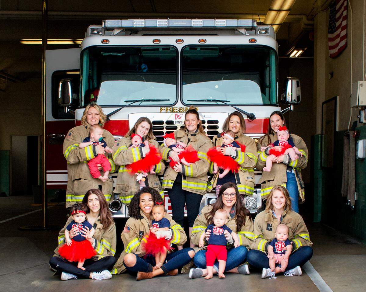 Babies of Fresno firefighters pictured with their mothers, wearing their husbands’ fire jackets, in February at Fresno Fire Station 3.