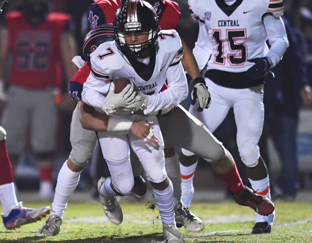 Central’s J. Nathan Vitolas tries to spin free of San Joaquin Memorial’s Gavin Zuniga in a Central Section semifinal game Friday, Nov. 19, 2021 in Fresno. Central won 37-20.